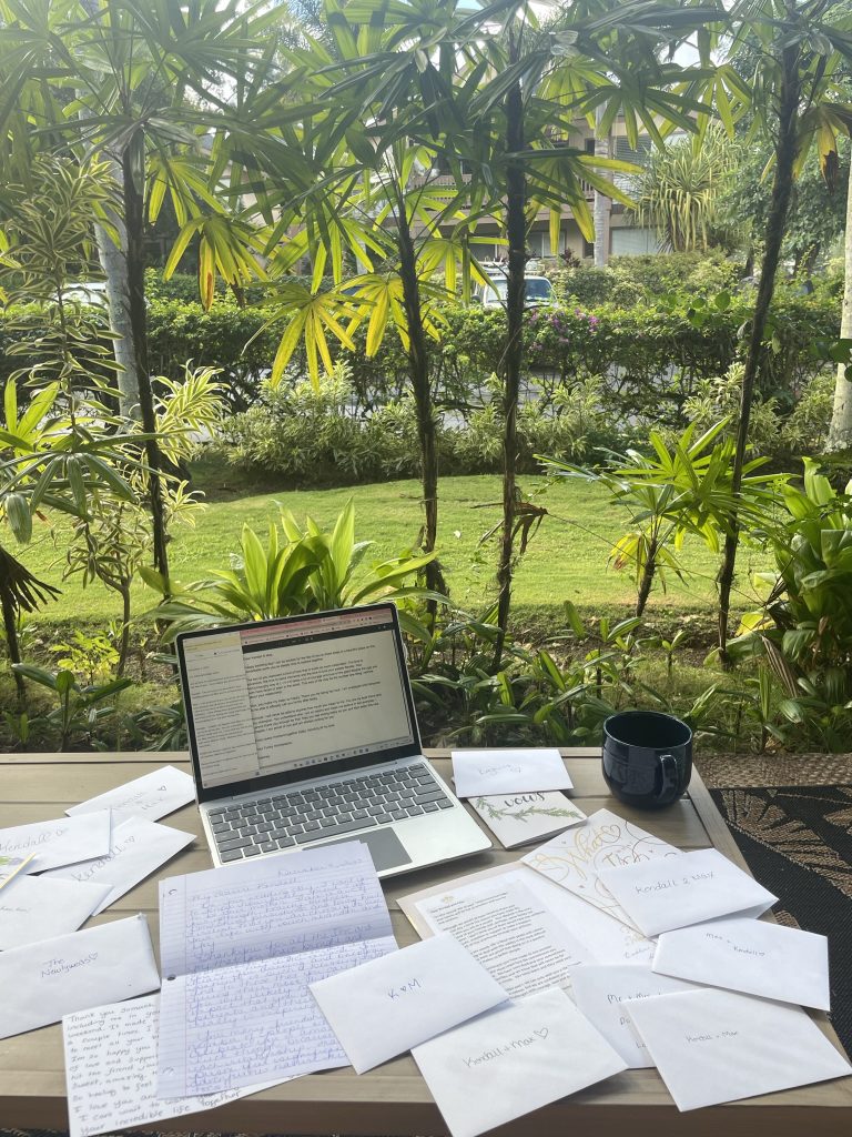 a coffee table filled with letters and notes and envelopes in a lanai in kauai