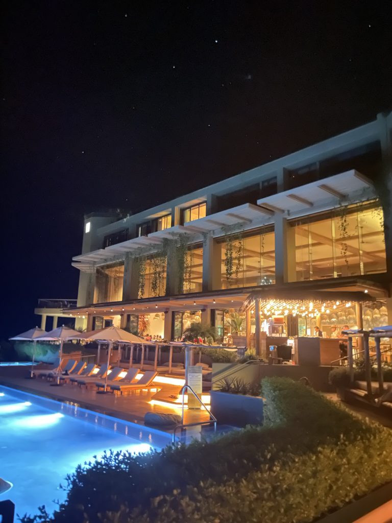 1 Hotel Hanalei Bay at night. View of the fancy hotel and pool with string lights and tropical vines hanging from every balcony