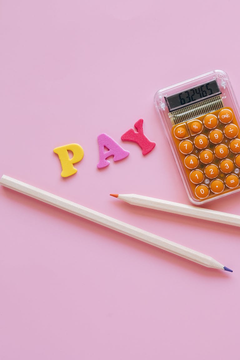 Vibrant calculator and pens on a pink surface symbolizing negotiating travel nurse pay