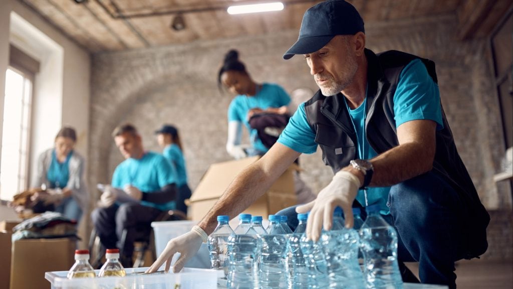 humanitarian volunteer nurses handing out bottled water and medicine
